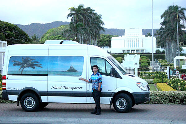 A man standing and holding a door of a shuttle service car.